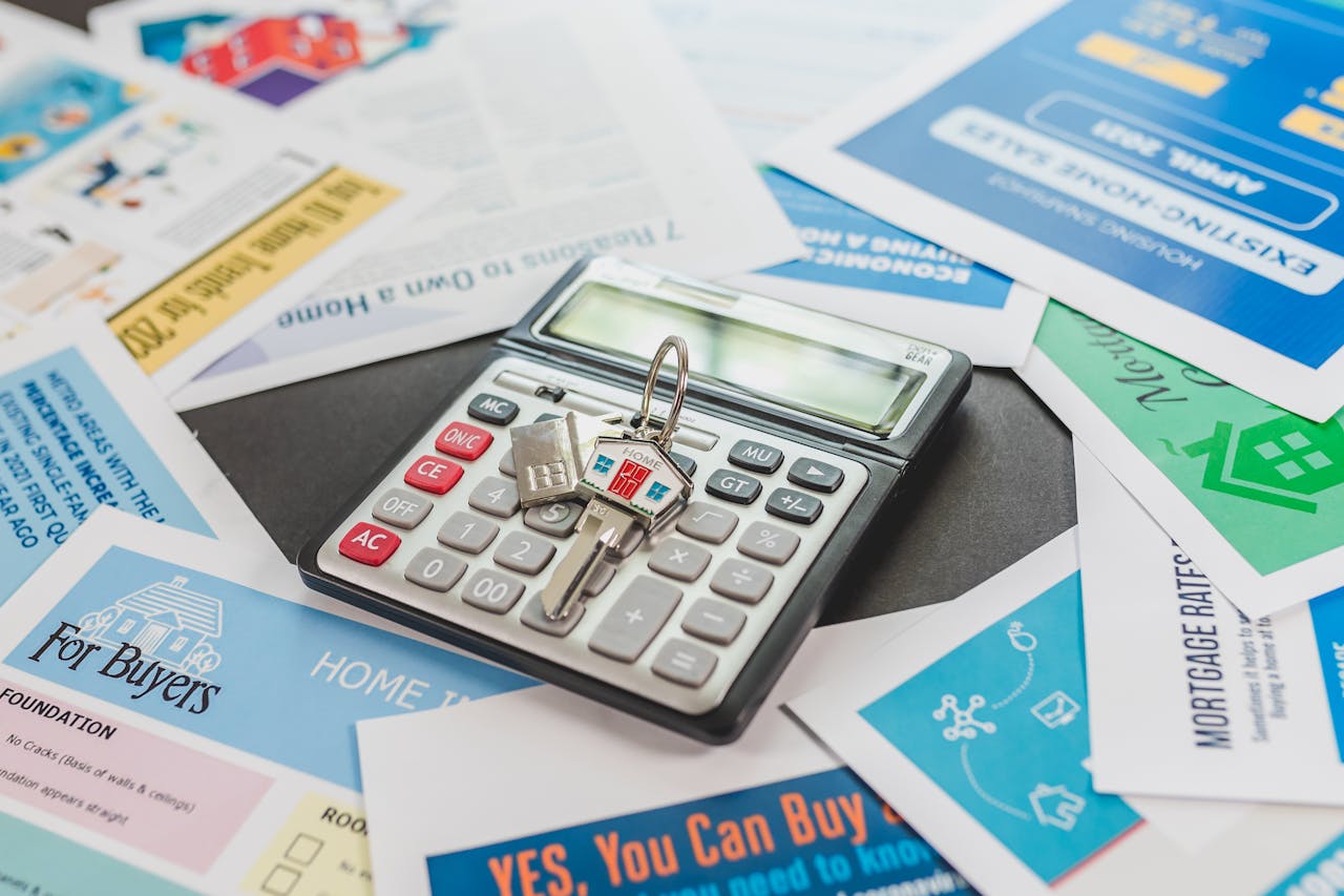 about-01 A calculator and real estate flyers depicting financial planning for home buyers.